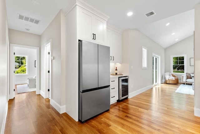 28 Marlboro Rd, Woburn, MA 01801 - kitchen featuring stainless steel fridge, beverage cooler, light wood-style flooring, white cabinetry, and vaulted ceiling
