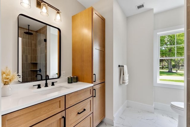 28 Marlboro Rd, Woburn, MA 01801 - bathroom with marble look tiles, vanity, toilet, tiled shower, and baseboards