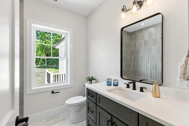 28 Marlboro Rd, Woburn, MA 01801 - bathroom featuring vanity, toilet, marble look tile flooring, and baseboards