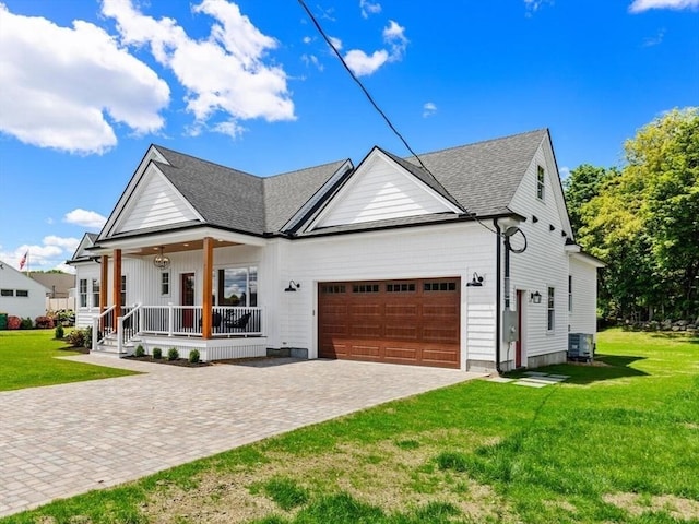 28 Marlboro Rd, Woburn, MA 01801 - view of front of house with covered porch, an attached garage, decorative driveway, a front lawn, and central AC unit