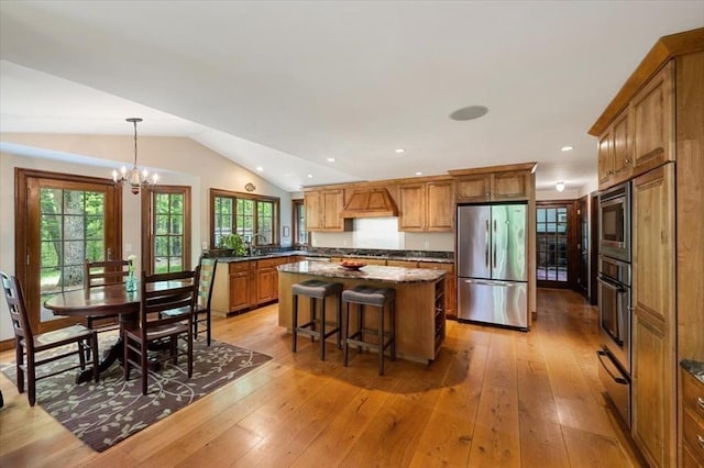 94 Middleton Rd, Boxford, MA 01921 - kitchen with stainless steel appliances, brown cabinetry, a center island, plenty of natural light, and vaulted ceiling