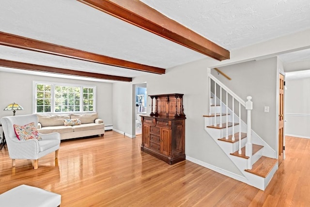32 Gannett Pasture Ln, Scituate, MA 02066 - living area featuring light wood-style flooring, a baseboard radiator, stairway, beam ceiling, and a textured ceiling