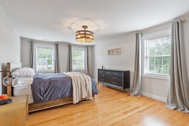 35 Lucaya Cir, Wilmington, MA 01887 - bedroom with multiple windows, light wood-type flooring, baseboards, and a chandelier