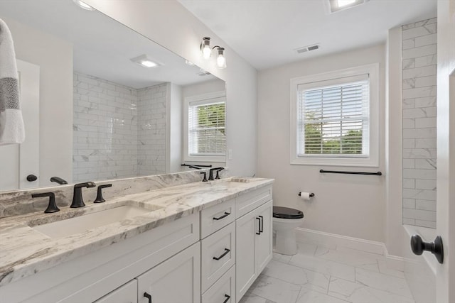 35 Lucaya Cir, Wilmington, MA 01887 - bathroom featuring marble look tiles, double vanity, toilet, tiled shower, and baseboards