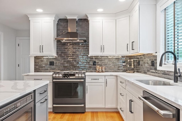 35 Lucaya Cir, Wilmington, MA 01887 - kitchen with range with gas stovetop, stainless steel dishwasher, wall chimney range hood, a sink, and white cabinets