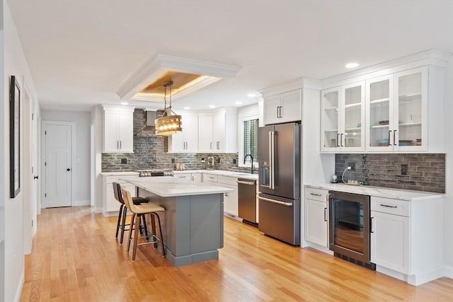 35 Lucaya Cir, Wilmington, MA 01887 - kitchen with appliances with stainless steel finishes, beverage cooler, wall chimney exhaust hood, decorative backsplash, and recessed lighting