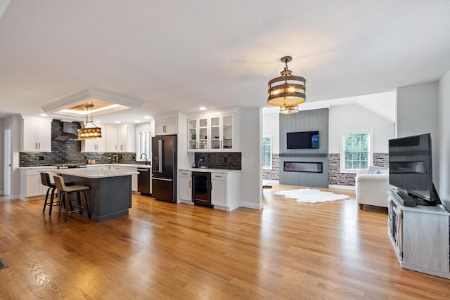 35 Lucaya Cir, Wilmington, MA 01887 - kitchen featuring wall chimney exhaust hood, high quality fridge, open floor plan, beverage cooler, and a fireplace