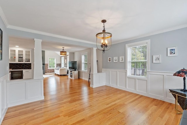 35 Lucaya Cir, Wilmington, MA 01887 - unfurnished dining area featuring wine cooler, a chandelier, ornamental molding, light wood-style floors, and wainscoting