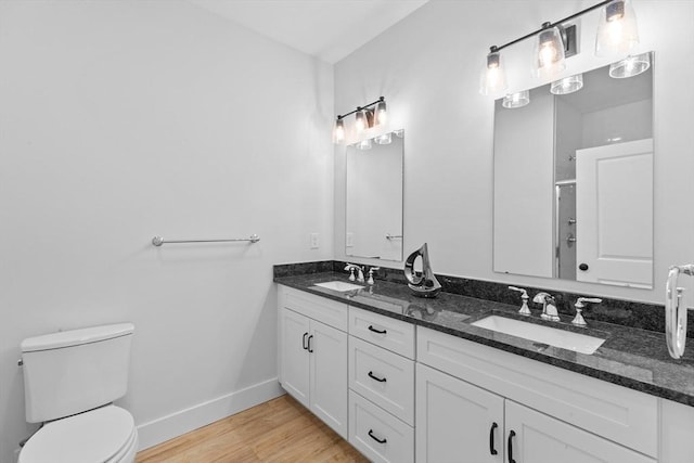 bathroom featuring vanity, toilet, wood-type flooring, and walk in shower