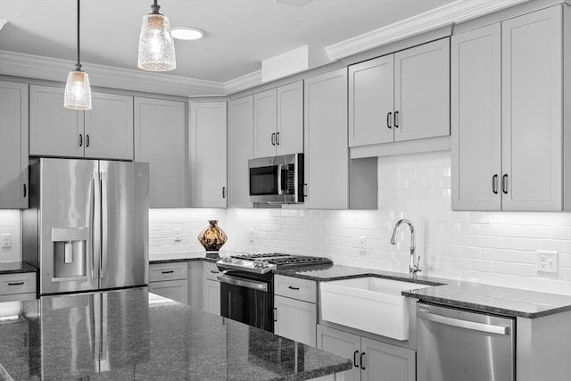 kitchen featuring gray cabinets, dark stone countertops, stainless steel appliances, and tasteful backsplash