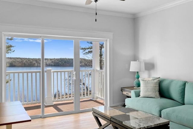 living room with a water view, ceiling fan, crown molding, and light hardwood / wood-style floors