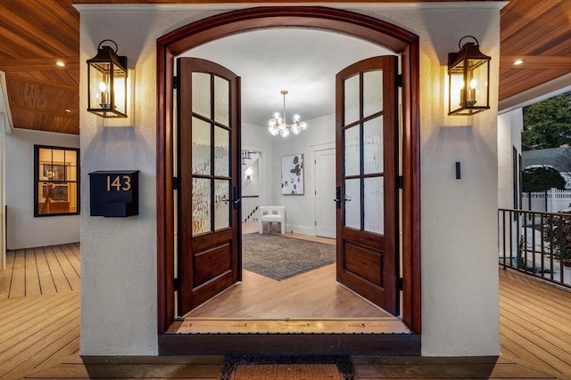 interior space with french doors, a notable chandelier, and wooden ceiling