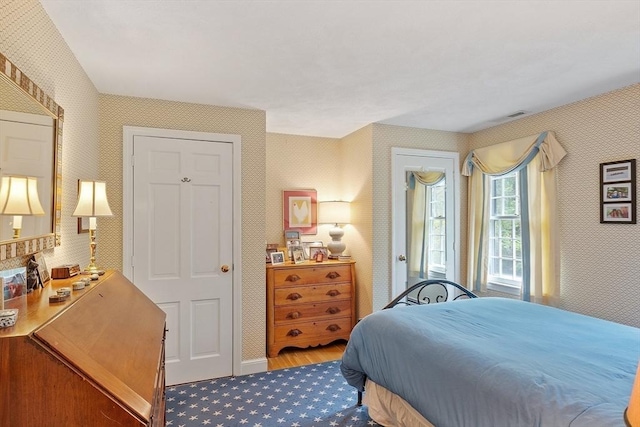 carpeted bedroom with wallpapered walls and baseboards