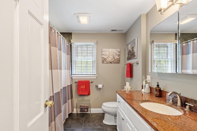 full bathroom featuring healthy amount of natural light, toilet, tile patterned floors, and vanity