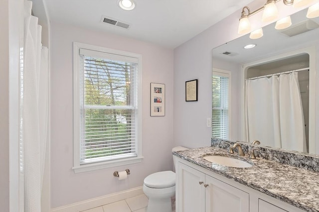 bathroom featuring healthy amount of natural light, baseboards, tile patterned floors, and toilet
