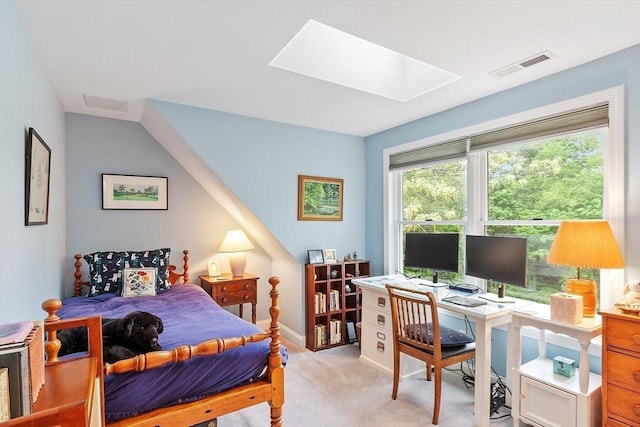 bedroom with a skylight, light carpet, and an office area