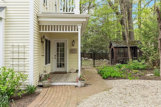 entrance to property with fence and a balcony