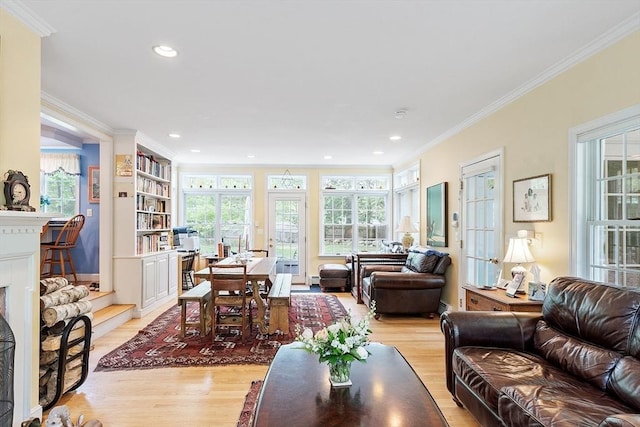 living room with light wood-style floors, crown molding, recessed lighting, and a fireplace