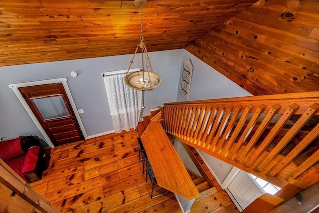 stairway featuring hardwood / wood-style flooring, wooden ceiling, and lofted ceiling