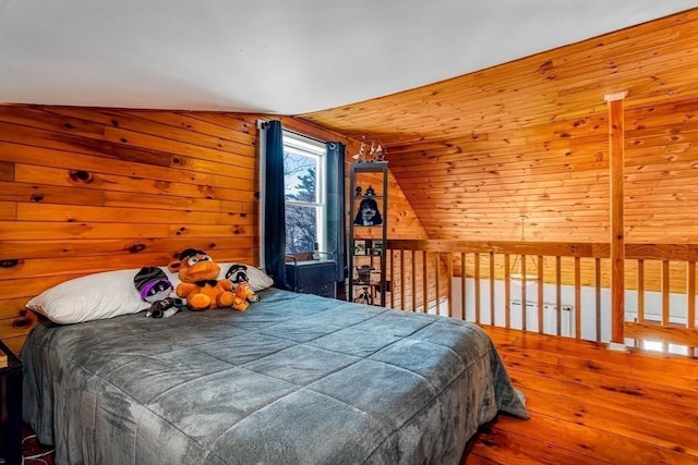 bedroom featuring wooden walls, hardwood / wood-style floors, and lofted ceiling