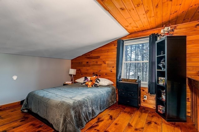 bedroom with lofted ceiling, wooden walls, wood ceiling, and dark hardwood / wood-style floors