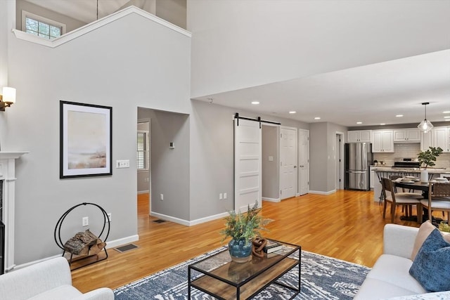 21 Mcdonough Dr, Marlborough, MA 01752 - living area featuring a barn door, light wood-style flooring, baseboards, recessed lighting, and plenty of natural light