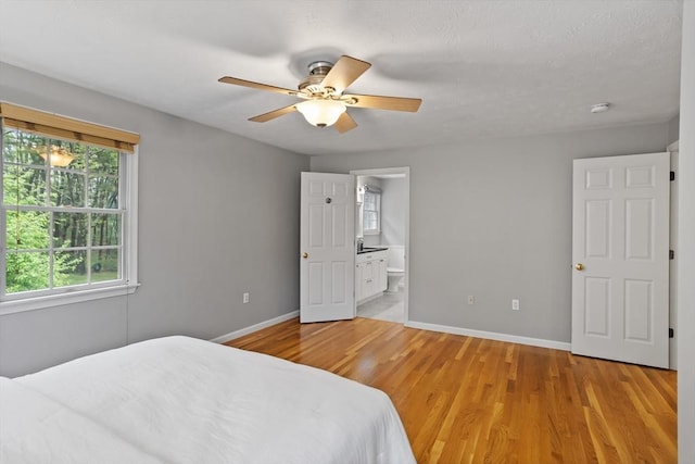 21 Mcdonough Dr, Marlborough, MA 01752 - bedroom with light wood-style flooring, baseboards, connected bathroom, and ceiling fan