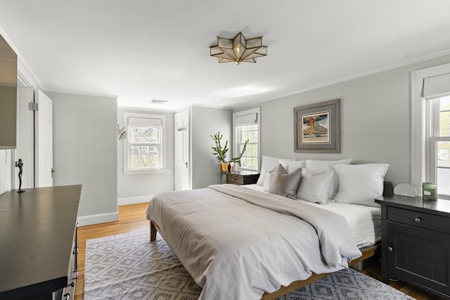 bedroom featuring crown molding, baseboards, and light wood-type flooring