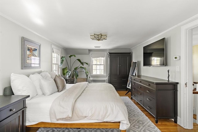 bedroom featuring visible vents, ornamental molding, and dark wood finished floors
