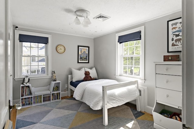 bedroom featuring crown molding, baseboards, visible vents, and multiple windows