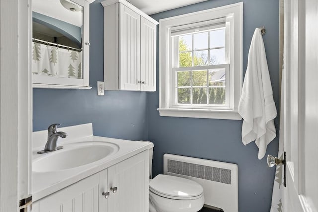 full bathroom featuring toilet, radiator, and vanity