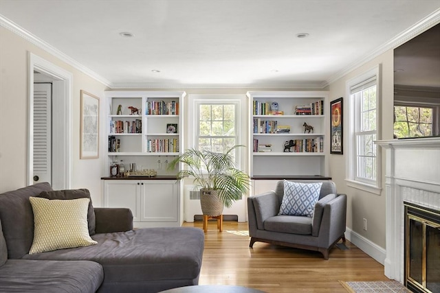 sitting room featuring crown molding, baseboards, a fireplace with flush hearth, and light wood-style floors