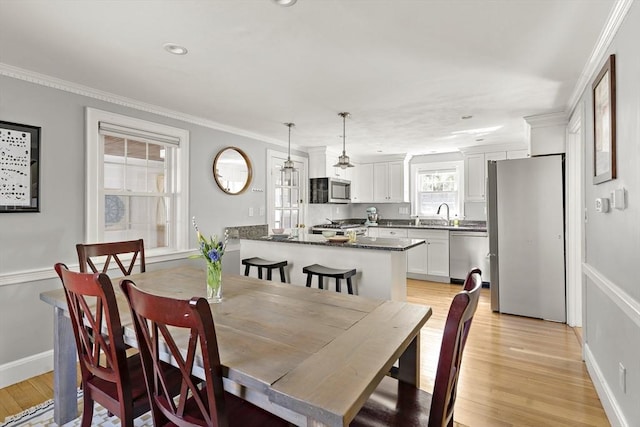 dining space featuring baseboards, ornamental molding, recessed lighting, and light wood-style flooring