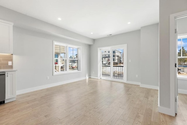 unfurnished living room with light wood finished floors, recessed lighting, and baseboards