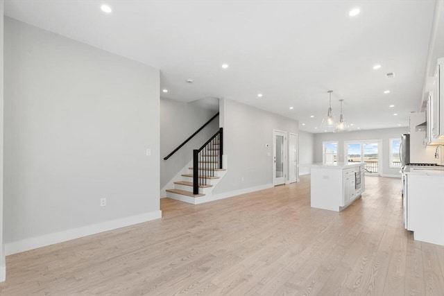 kitchen featuring a center island, white cabinets, light wood finished floors, and recessed lighting