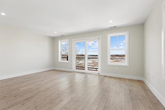 empty room with recessed lighting, baseboards, visible vents, and light wood finished floors