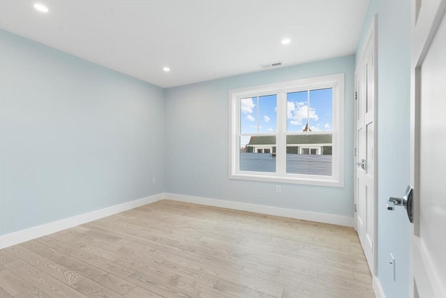 unfurnished room featuring light wood-type flooring, visible vents, baseboards, and recessed lighting