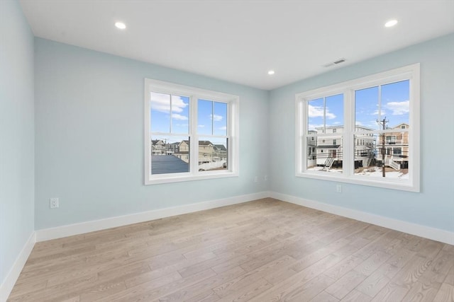 unfurnished room featuring light wood-style floors, recessed lighting, and baseboards