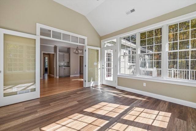 unfurnished sunroom featuring french doors, a notable chandelier, and lofted ceiling