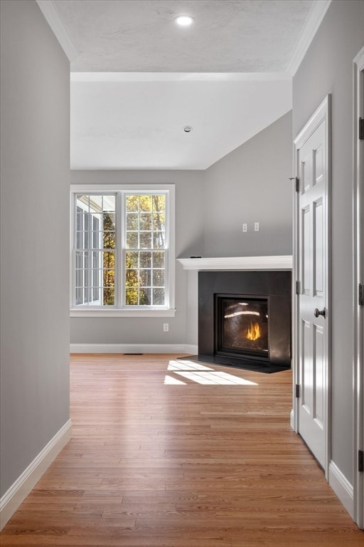 unfurnished living room with ornamental molding and light hardwood / wood-style floors