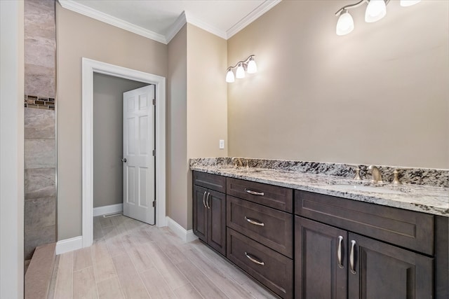 bathroom with crown molding, hardwood / wood-style floors, and vanity