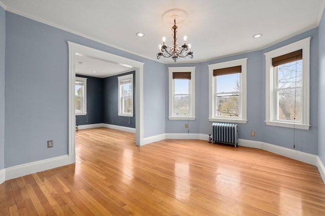 unfurnished dining area with radiator, a wealth of natural light, light wood-style floors, and ornamental molding