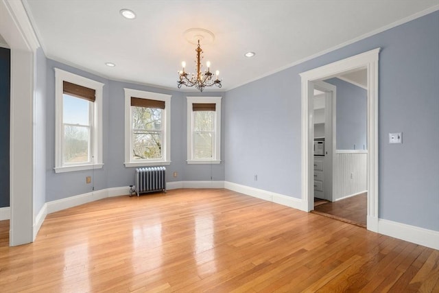 unfurnished dining area featuring crown molding, radiator, and a notable chandelier