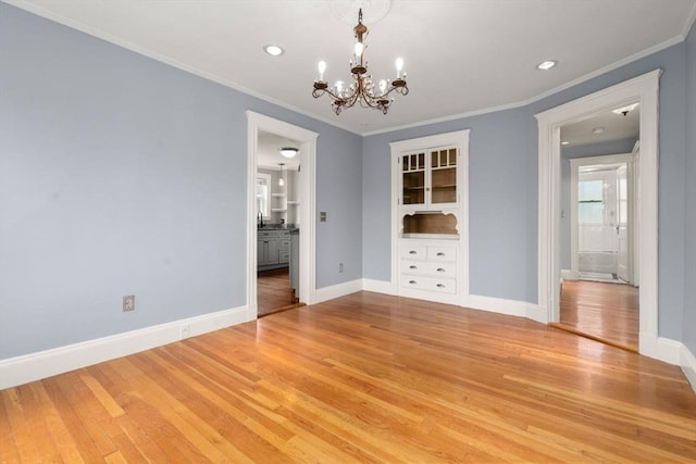 unfurnished dining area with light wood finished floors, a chandelier, and baseboards