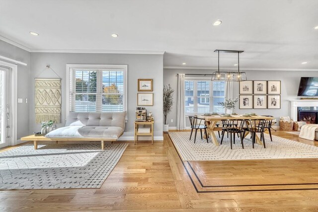 dining room featuring crown molding, a wealth of natural light, and light hardwood / wood-style flooring