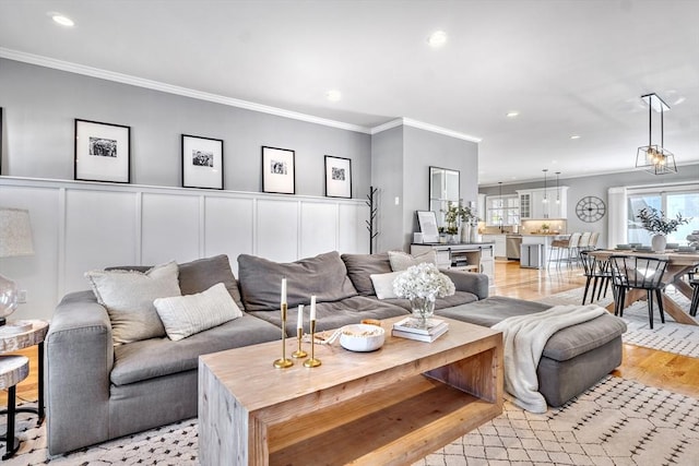 living room with crown molding and light hardwood / wood-style floors