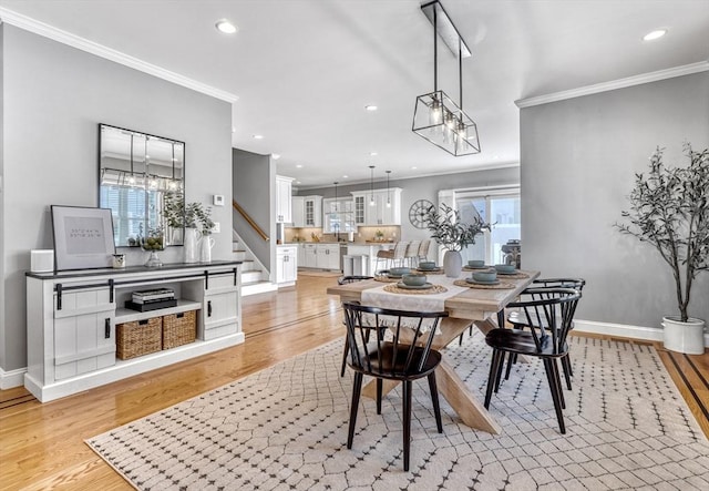 dining space featuring ornamental molding, light hardwood / wood-style flooring, and a wealth of natural light