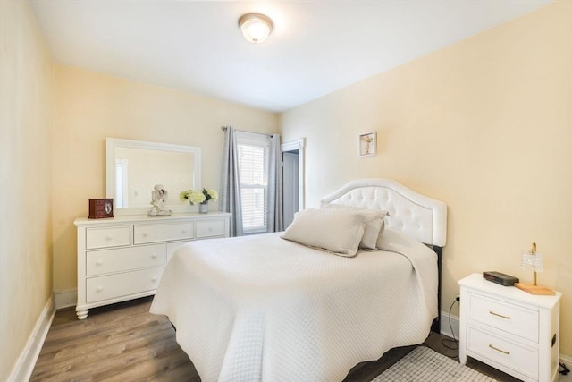 bedroom with baseboards and wood finished floors