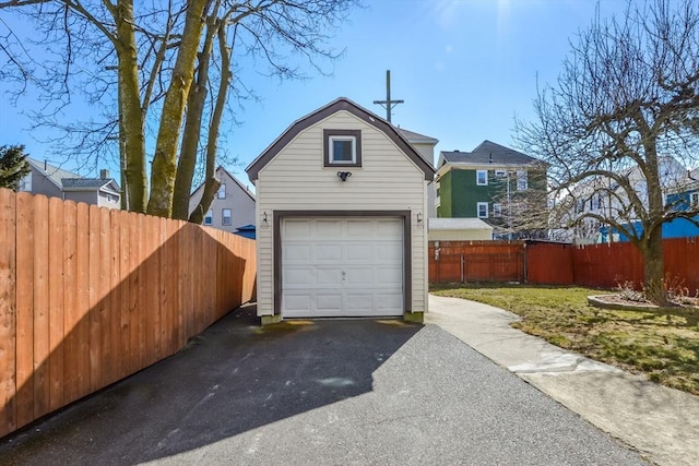 detached garage with aphalt driveway and fence