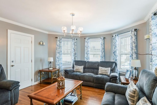 living room with crown molding, a notable chandelier, wood finished floors, and baseboards